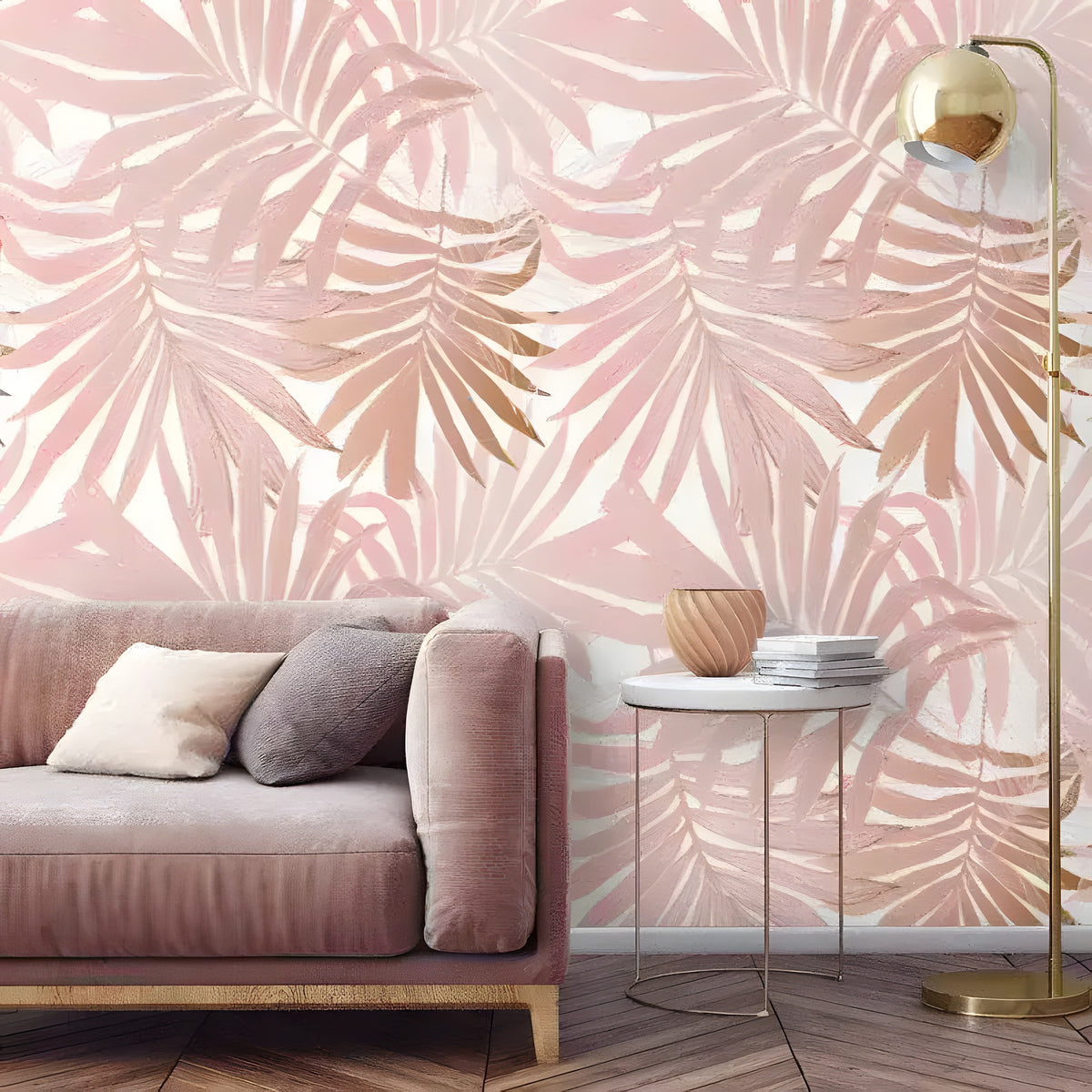 Blush pink palm leaves tropical wallpaper on a living room wall behind a dusty rose sofa and brass floor lamp