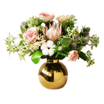 Cotton rose floral arrangement with pink roses, protea, cotton bolls, and thistles in a round shiny gold pot