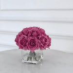 Mauve purple silk rose centerpiece in a square glass vase with simulated water on marble surface