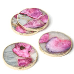 Set of 4 round pink agate geode coasters with gold trim showing vivid pink and grey crystal formations