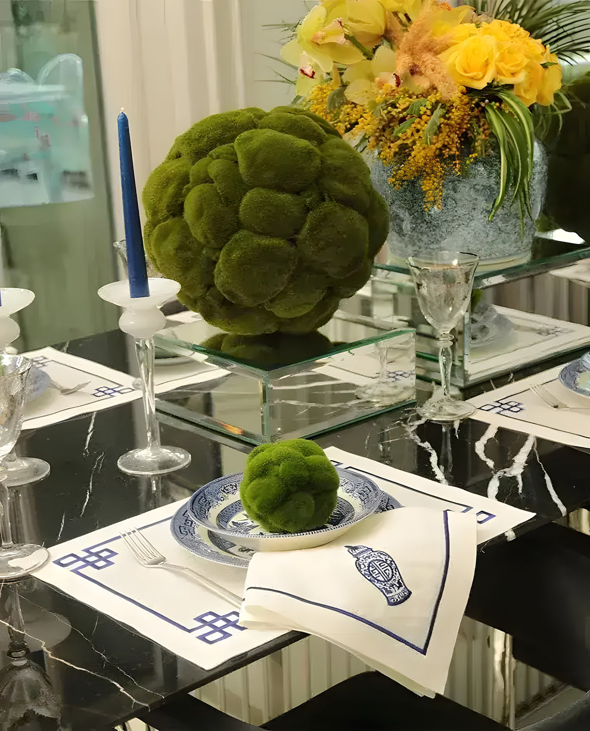 Linen Greek placemat with navy blue geometric meander border, blue chinoiserie plates and gold cutlery