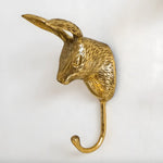 Single brass rabbit head wall hook, textured fur, upright ear, polished gold finish, curved hook below, close-up