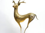 Brass deer figurine — slender antlered stag in polished gold with engraved geometric dot patterns on body