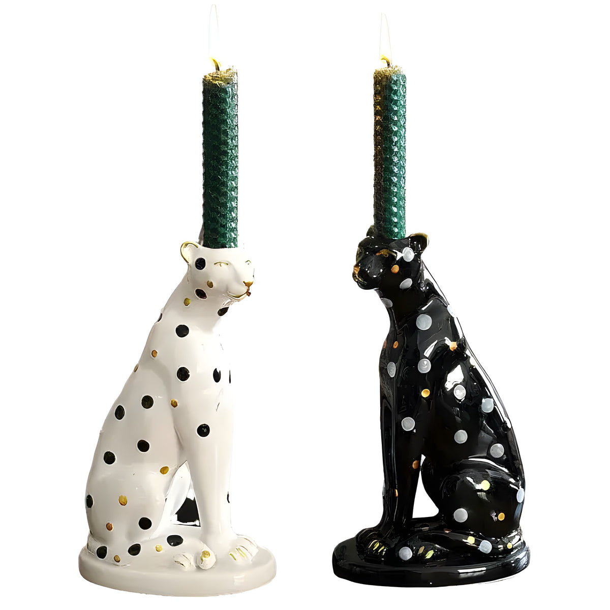 White and black ceramic leopard candle holders with black and silver spots, each holding a green taper candle