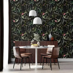 Green and black floral wallpaper in a dining room, dark botanical with green leaves and pink blooms, round white table