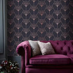 Purple Art Deco Diamonds wallpaper in dark charcoal with rose gold diamond-fan motifs, beside a tufted burgundy velvet sofa