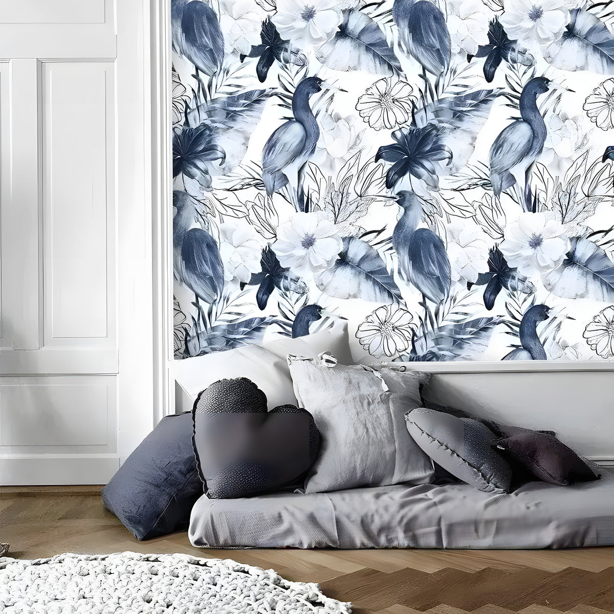 Blue and white tropical birds wallpaper with navy parrots and white hibiscus flowers, above a grey floor cushion with heart pillow