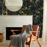 Dark Hawaiian Ferns wallpaper in a living room — navy ground with tropical ferns and bird-of-paradise flowers, marble fireplace