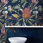 Exotic Flowers and Leaves watercolor wallpaper on dark navy in bathroom with marble vessel sink, gold tap