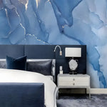 Abstract Blue Marble Mural above navy bed with dark pillows and silver nightstand, fluid blue ink with silver veins