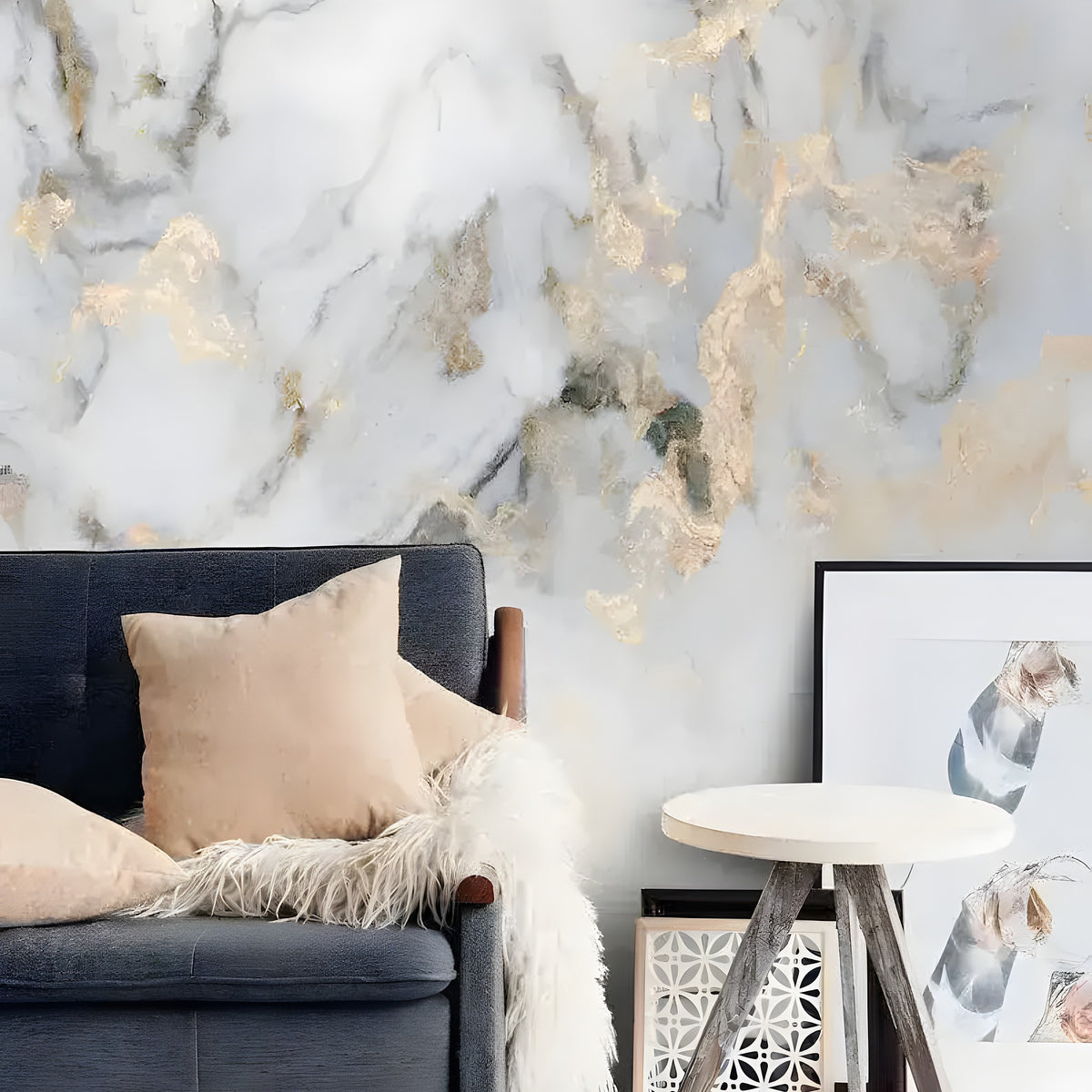 Faux gold and marble mural beside charcoal sofa with fur throw and framed art in a minimalist room