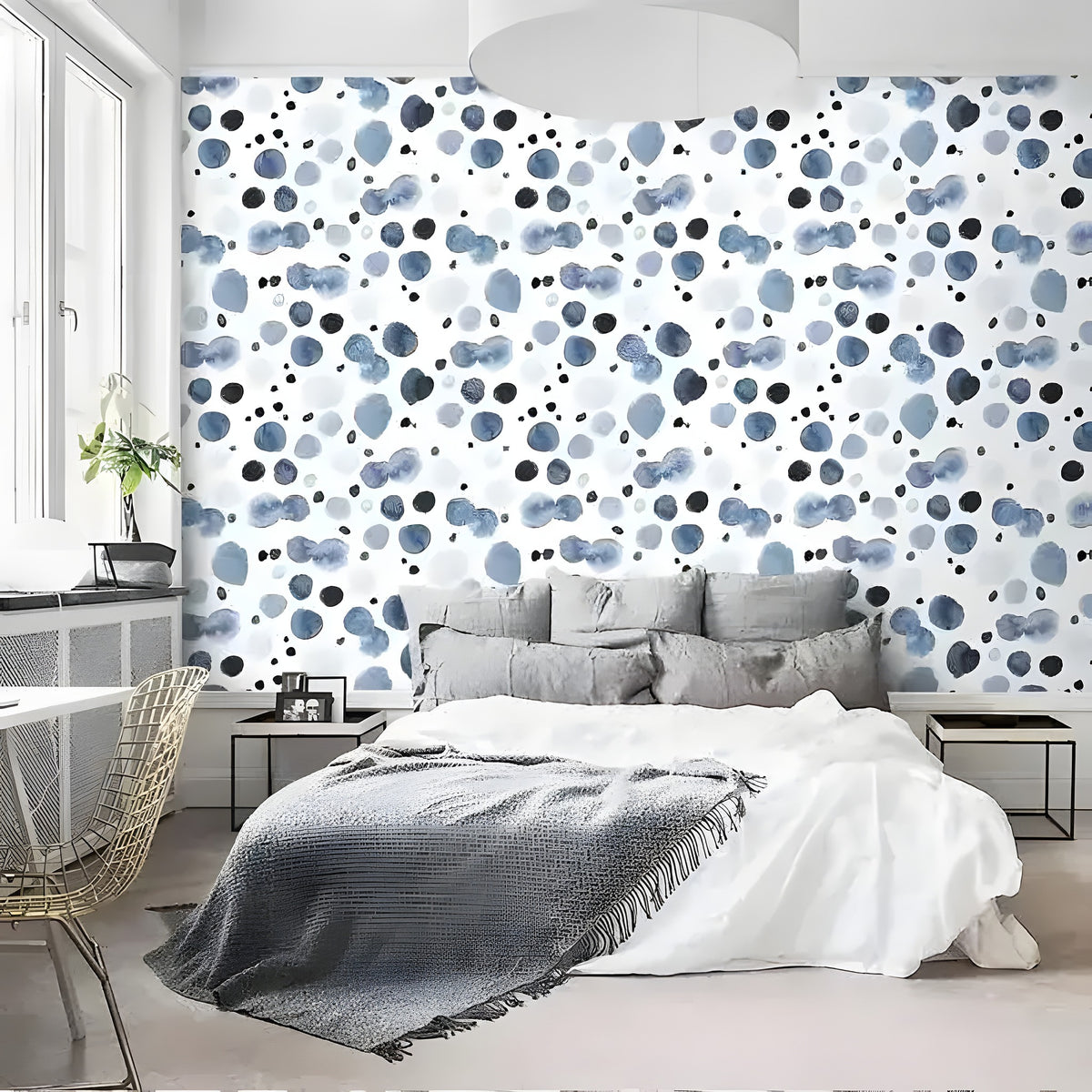 Watercolor blue abstract wallpaper with scattered indigo and navy dot pattern, shown in modern bedroom