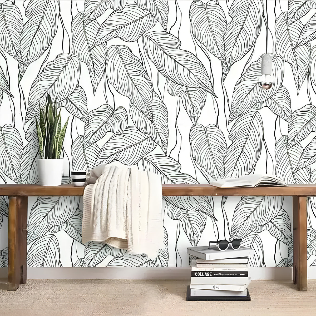 Oversized Monstera Leaves wallpaper behind rustic wood bench with snake plant and cream throw, large green leaf outlines on white