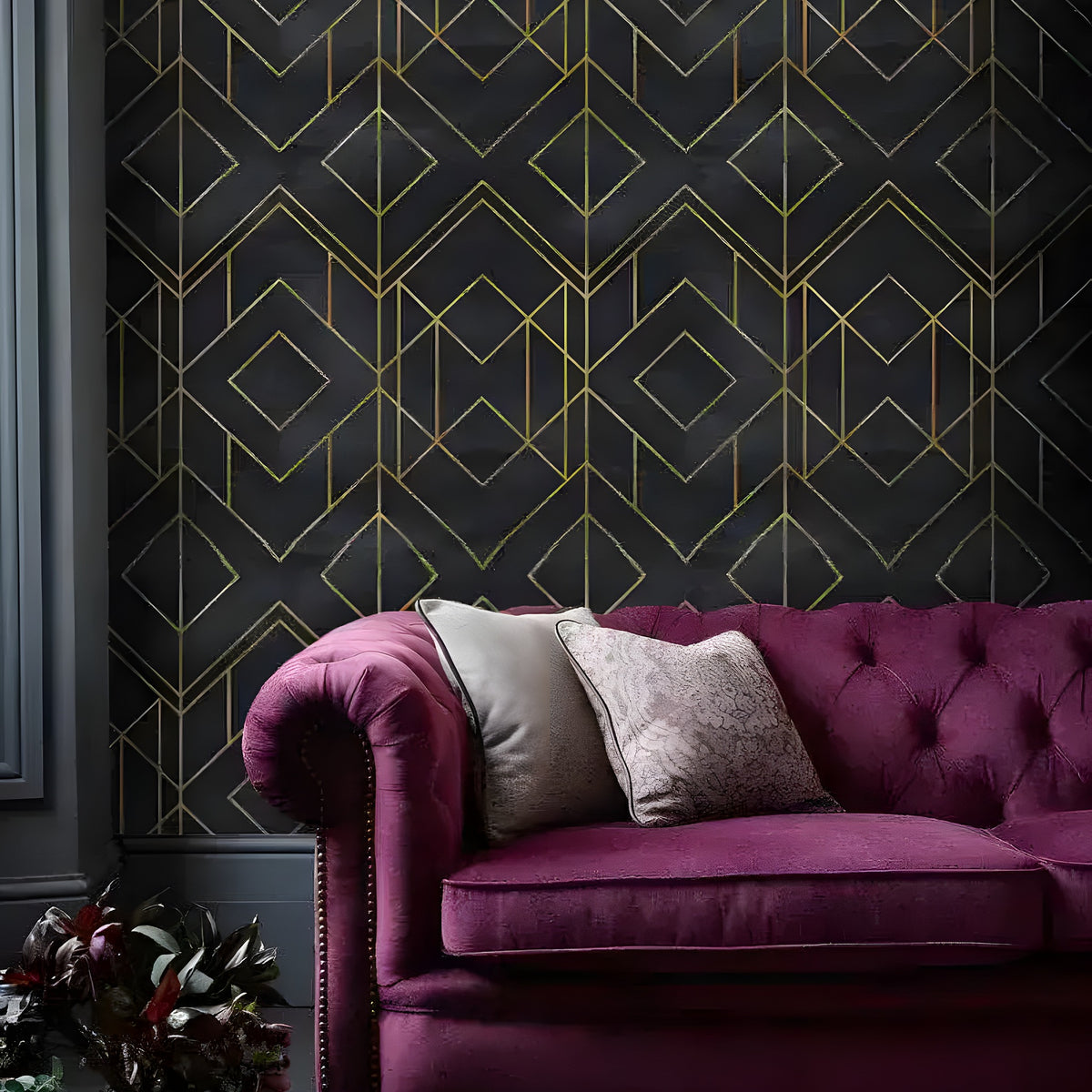 Faux gold and black art deco geometric wallpaper with diamond grid on dark marble behind plum velvet Chesterfield sofa