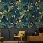 Hawaiian dark green tropical leaves wallpaper in moody living room with yellow armchair and wood credenza