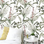 Birds of paradise botanical wallpaper in a bedroom with white linen and yellow knit cushion