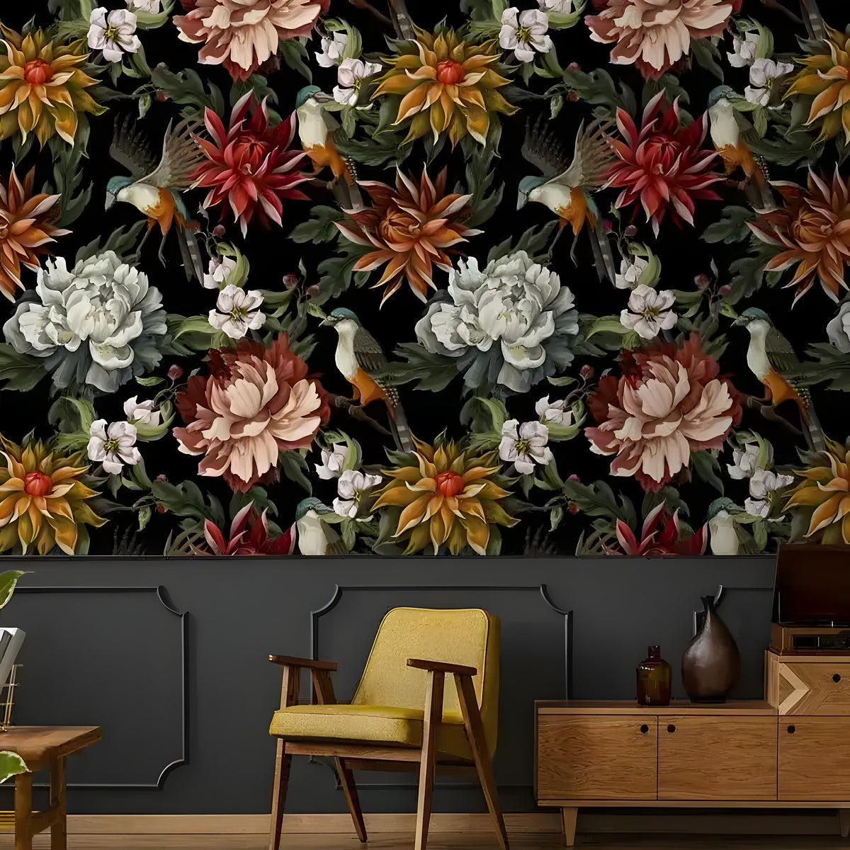 Vintage exotic flowers and birds on black wallpaper above gray paneling with a yellow mid-century chair and wood sideboard