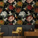 Vintage exotic flowers and birds on black wallpaper above gray paneling with a yellow mid-century chair and wood sideboard