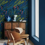 Dark blue watercolor botanical wallpaper with green leaves and coral berries in a Scandi corner with bentwood chair