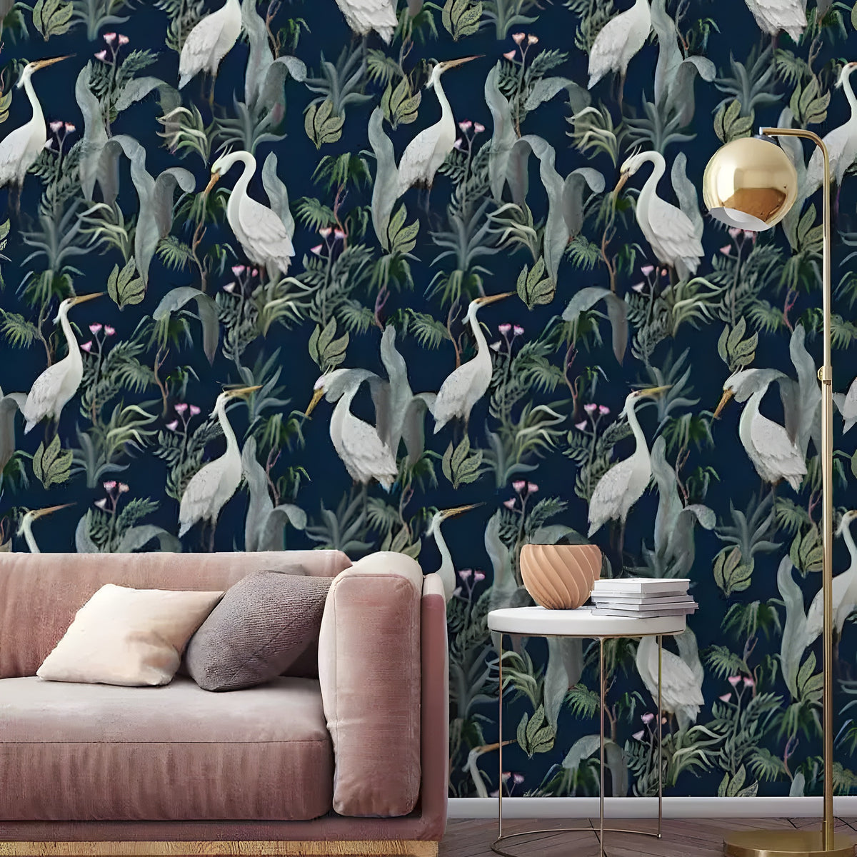 Navy tropical cranes wallpaper with white herons and green botanical foliage, styled with pink velvet sofa and gold lamp