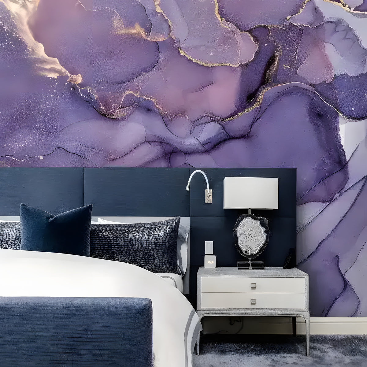 Dramatic Purple and Gold Abstract Marble mural above dark navy headboard, white lamp on gray nightstand