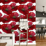 Red oversized poppies floral wallpaper with bold crimson blooms and green stems on white, with a rustic wooden ladder in an airy room