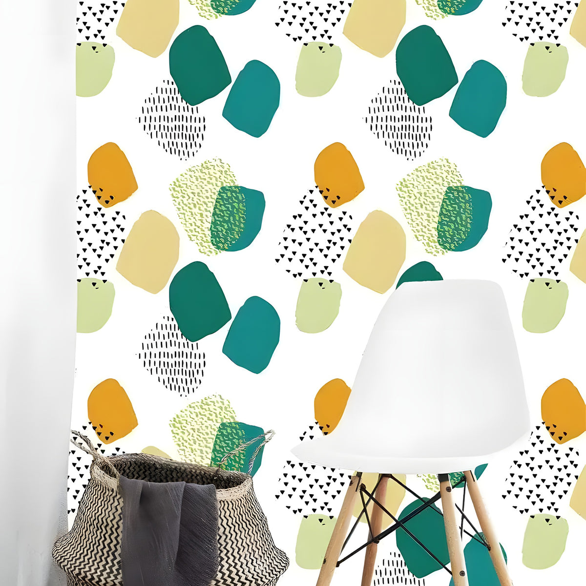 White wallpaper with scattered teal, amber and lime rounded abstract shapes beside white Eames chair and wicker basket