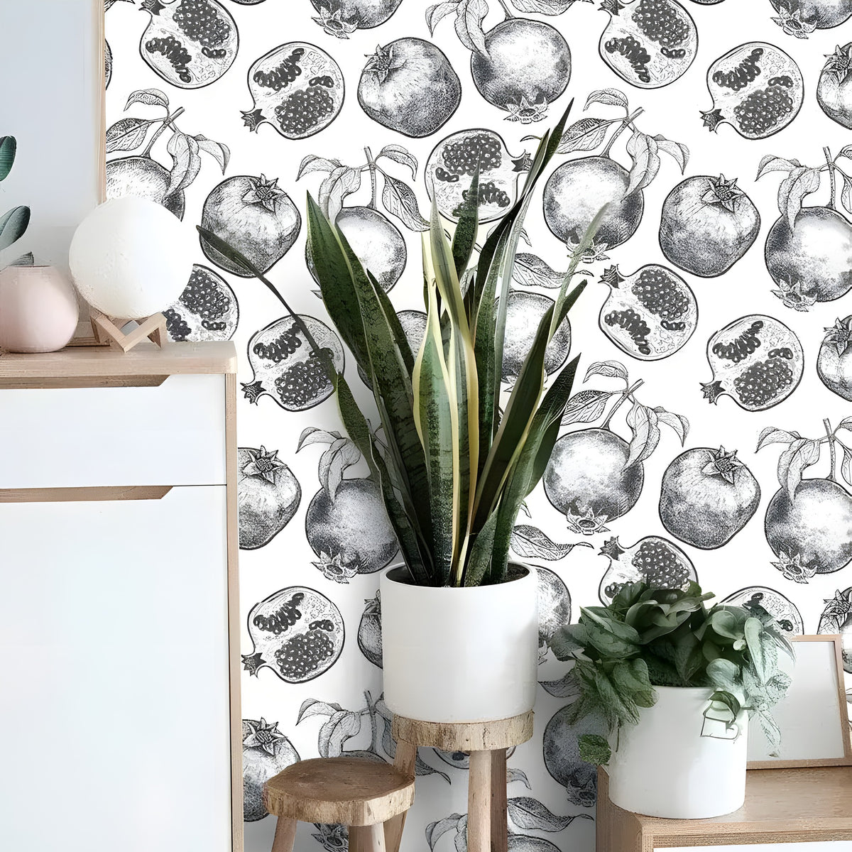 Multi-tone tropical leaves wallpaper in blue gray and gold on cream, with white armchair and rattan stool