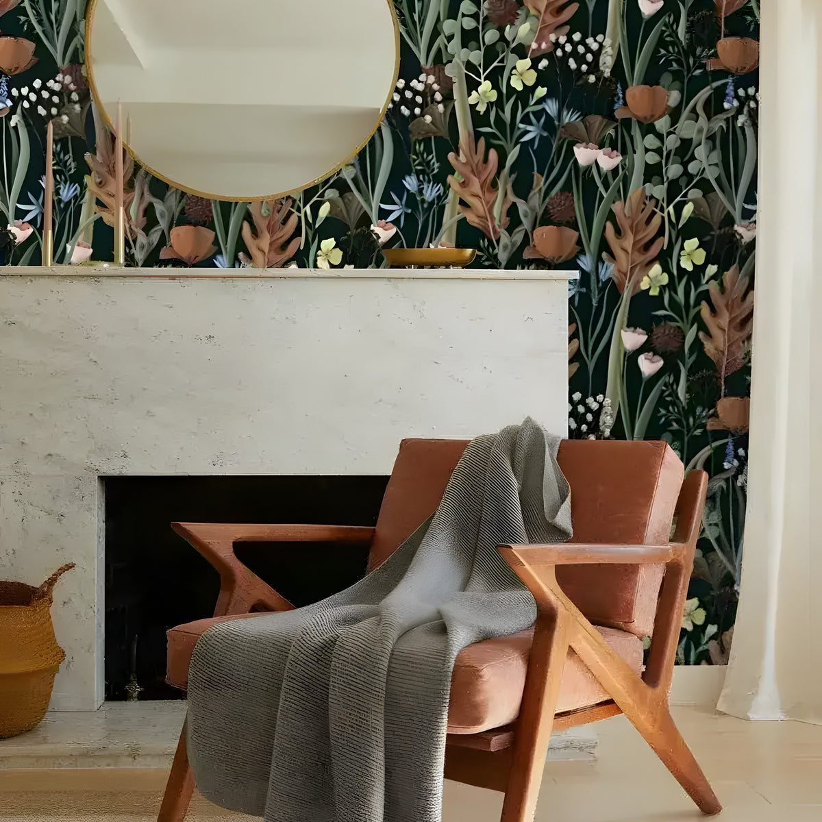 Dark botanical wildflower watercolor wallpaper beside marble fireplace with gold round mirror and terracotta armchair