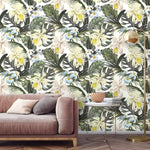 Living room with pink sofa and marble table; hawaiian tropical floral and monstera wallpaper with green leaves and white plumeria