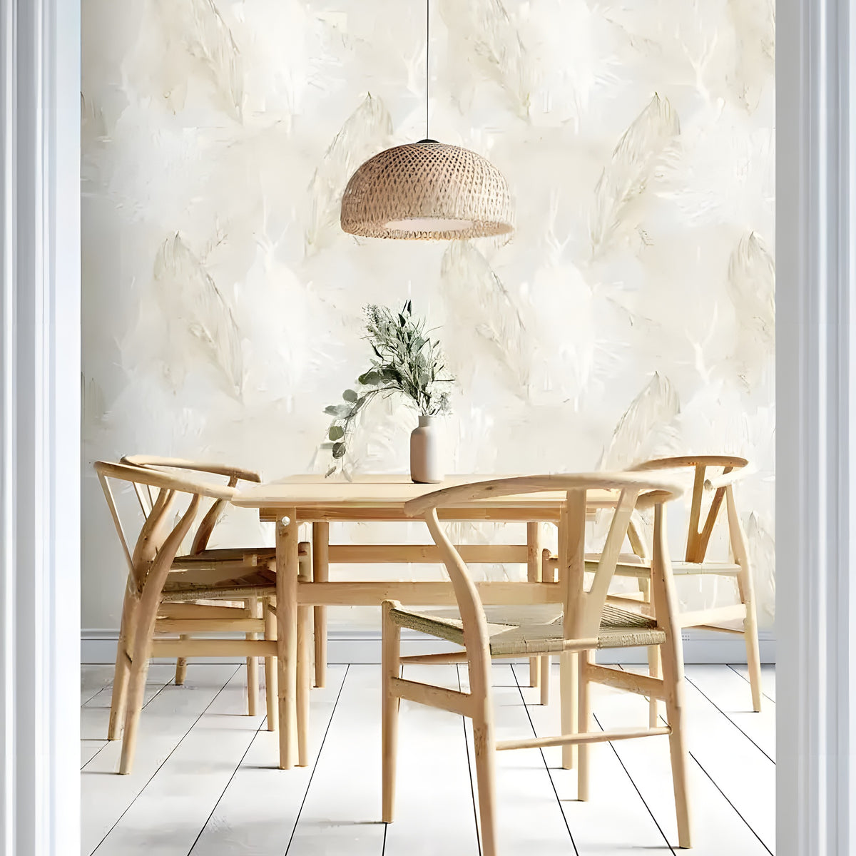 Neutral tropical leaves wallpaper in a dining room with wooden chairs, rattan pendant light, and white plank floor