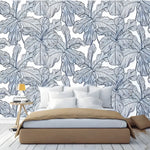 Blue line-art exotic leaves wallpaper as bedroom headboard feature wall with white background, tan platform bed and white pillows
