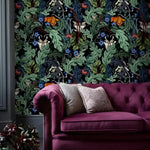 Vintage dark botanical wallpaper with acanthus leaves and skulls in a room with a burgundy velvet tufted sofa