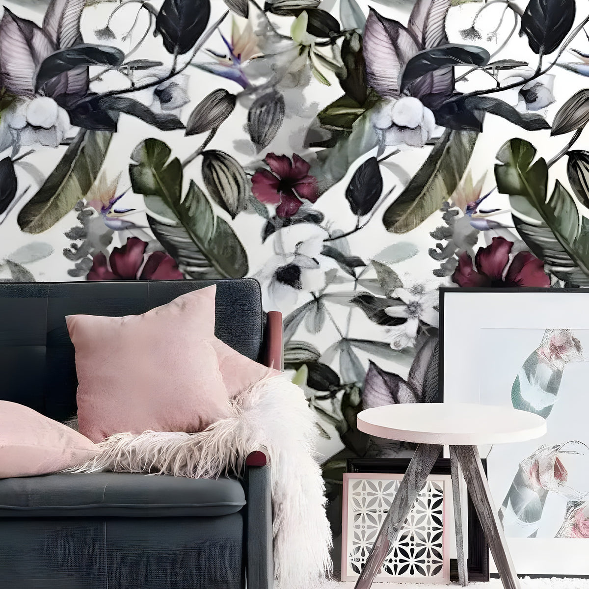Dramatic oversized exotic floral watercolor wallpaper with burgundy hibiscus and dark leaves behind grey sofa with pink pillow