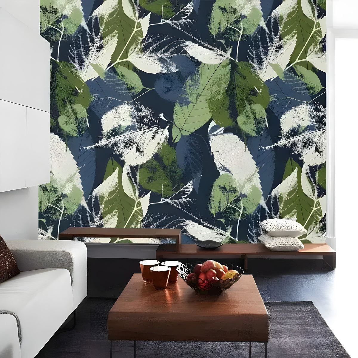 Dark navy botanical leaves wallpaper in a living room with sofa, wood coffee table and fruit bowl