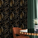 Dark golden birds botanical wallpaper in styled room with rust velvet chair and green curtain