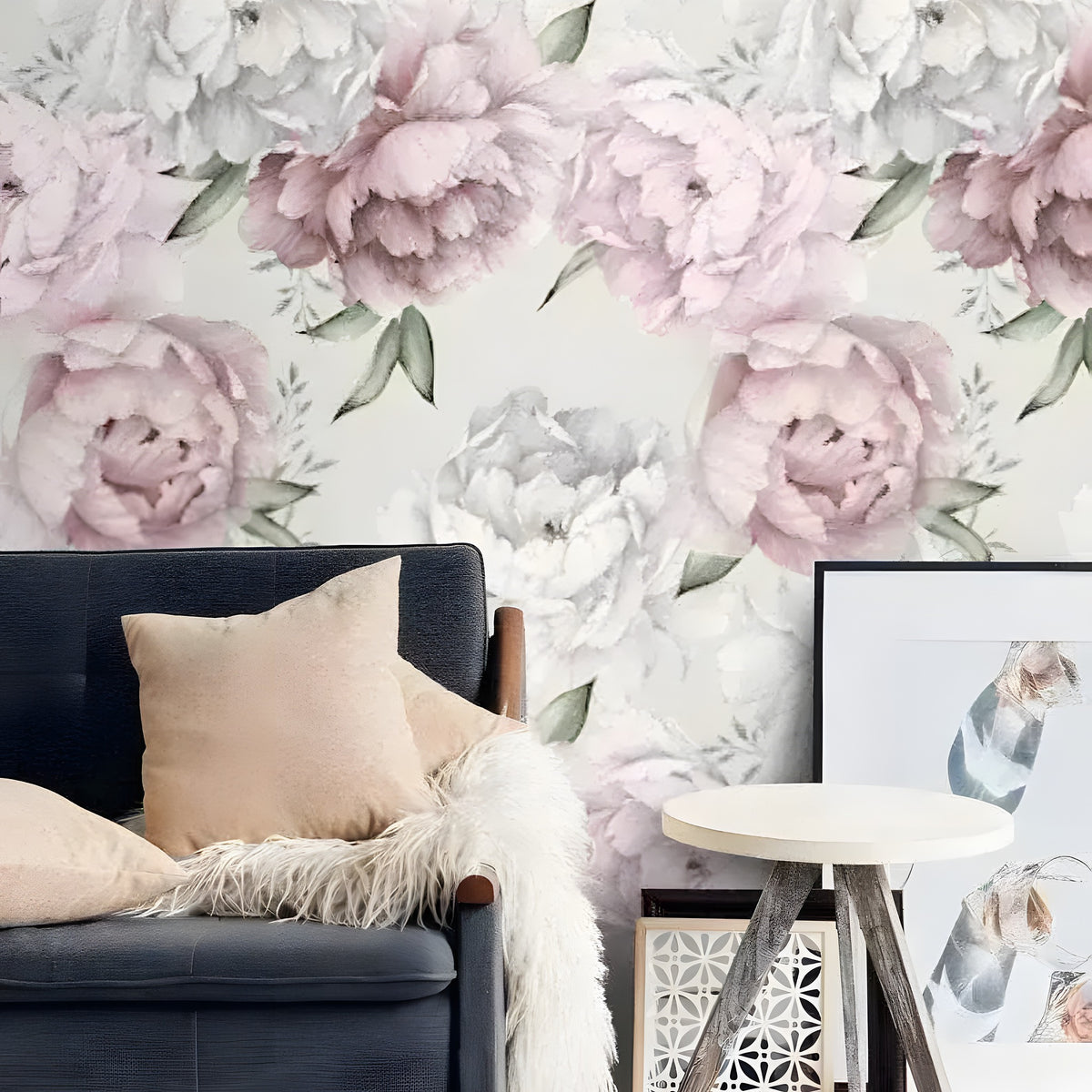 Floral oversized peony watercolor wallpaper with blush pink and white peony blooms behind navy sofa with gold cushions and fur throw