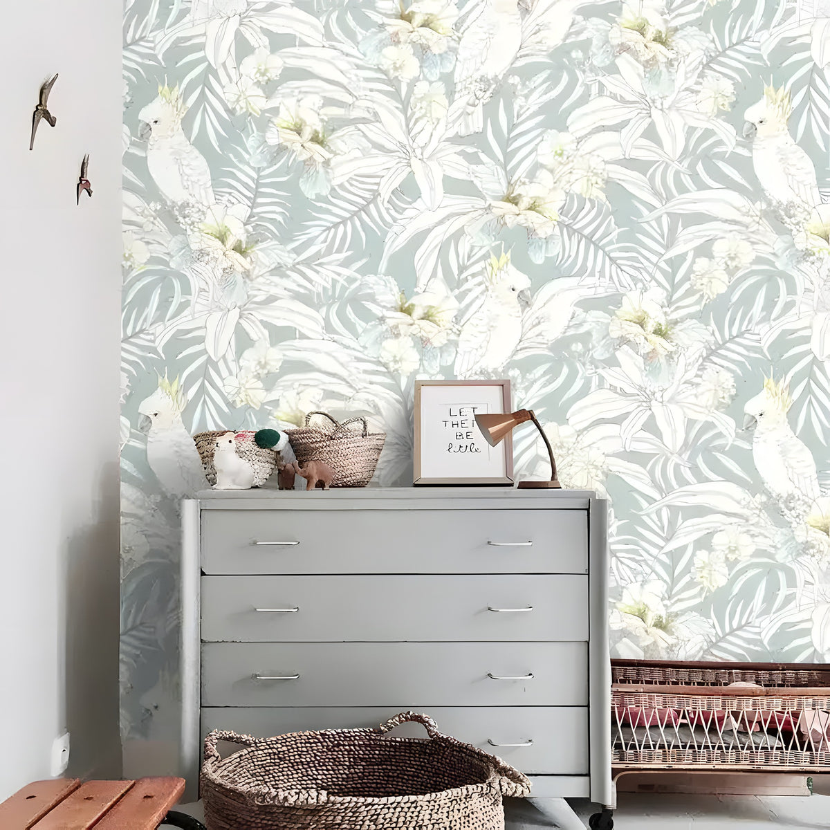 Sage green tropical parrot wallpaper with gray dresser, wicker baskets, swallow wall art