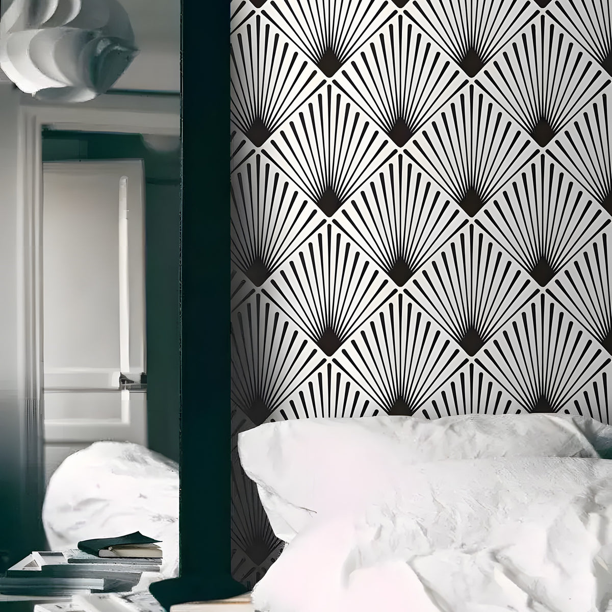 Black and white edgy art deco fan wallpaper as headboard wall behind white bed with stacked books and pendant lamp