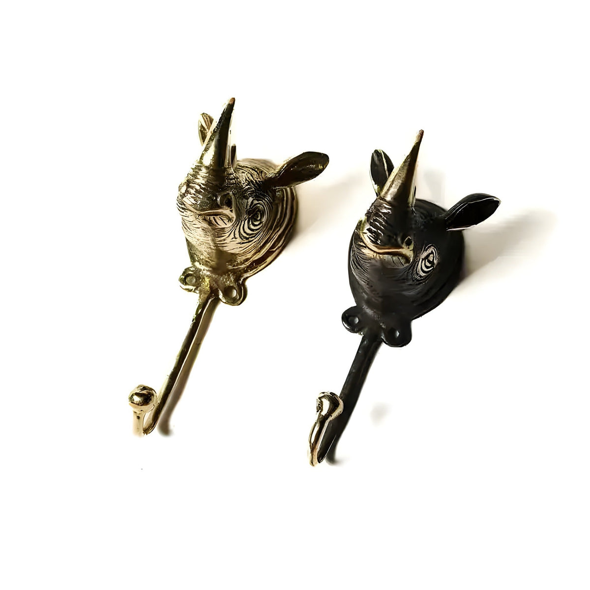 Two rhino head wall hooks side by side, polished gold and black finish, single horn, J-hook stem, white