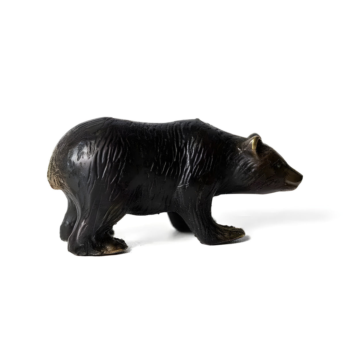 Dark bronze bear miniature sculpture in walking pose, side profile, gold-tipped ears and paws, white background