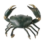 Life-size brass crab sculpture, top-down view, spread claws with gold tips, dark antique-green body