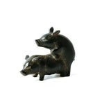 Two pig brass figurines in mating pose, smooth black polish finish, on white background