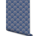 Art Deco Geometric Waves wallpaper roll showing navy blue scallop arches on beige, angled view