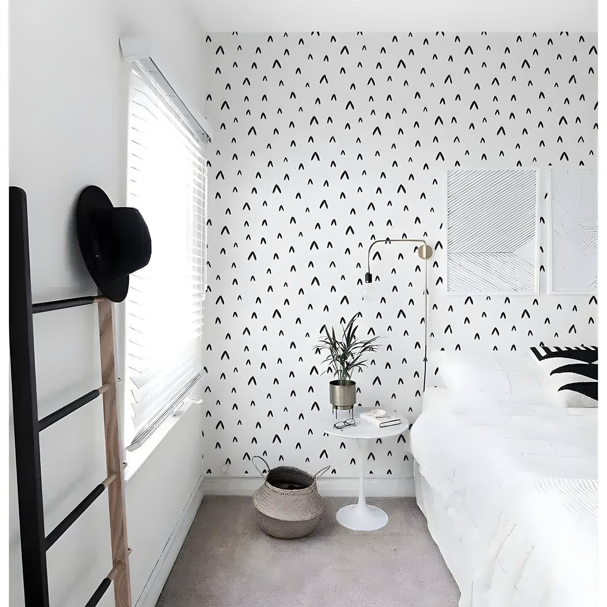 Black and white chevron removable wallpaper in a bright bedroom with white bedding and wooden ladder