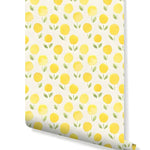 Wallpaper roll showing repeating yellow marigold blooms with green stems on a cream watercolor ground