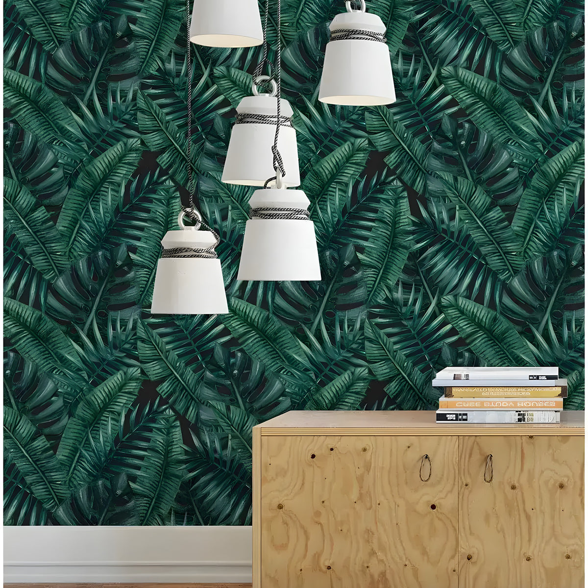 Tropical jungle monstera palm leaves wallpaper in dark green, styled with pendant lights and wood sideboard