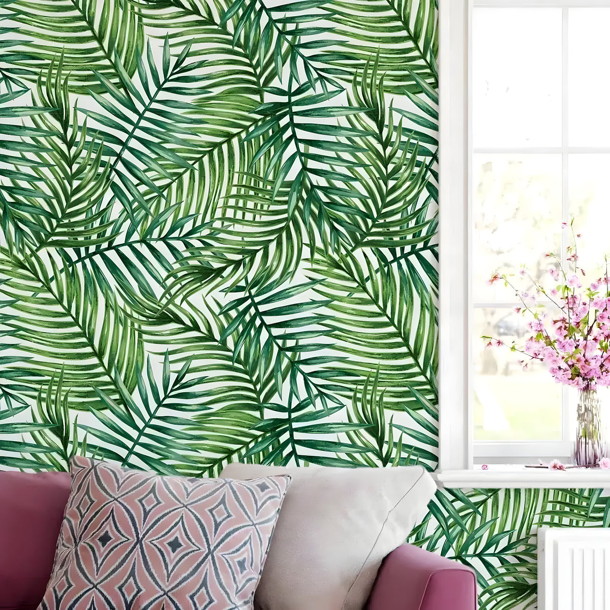 Watercolor tropical green palm leaves wallpaper on wall behind mauve sofa with pink floral cushion
