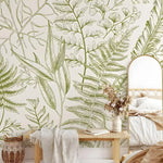 Light green fern botanical wall mural installed in a boho bedroom with rattan bench and arch mirror