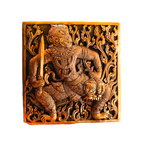 Close-up of engraved brass betel box lid with Hanuman warrior figure holding sword amid floral scrollwork